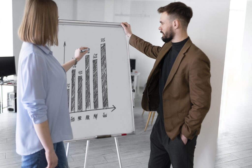 O que faz uma agência de tráfego pago na prática? 2 colegas de trabalho sexo masculino e feminino na mesma sala