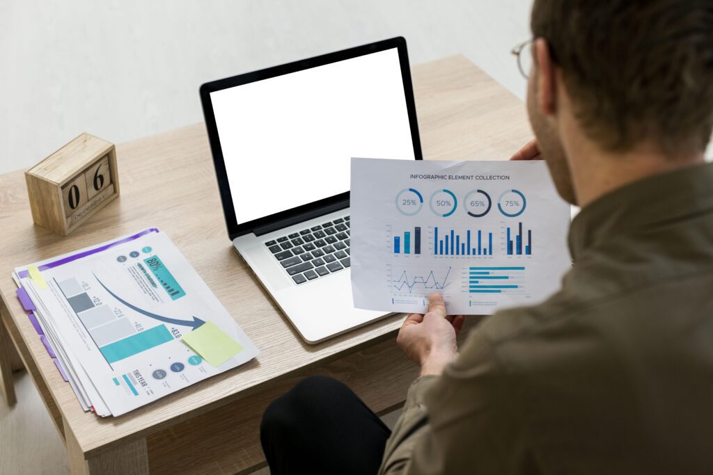 Como funciona um serviço de tráfego pago? Descubra tudo antes de contratar 2 homem trabalhando com infograficos em ambientes fechados